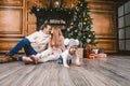 Family holiday New Year and Christmas. Young caucasian family mom dad son 1 year sit wooden floor near fireplace christmas tree on Royalty Free Stock Photo