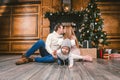 Family holiday New Year and Christmas. Young caucasian family mom dad son 1 year sit wooden floor near fireplace christmas tree on Royalty Free Stock Photo