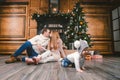 Family holiday New Year and Christmas. Young caucasian family mom dad son 1 year sit wooden floor near fireplace christmas tree on Royalty Free Stock Photo