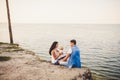 Theme family vacation with small child on the nature and sea. Mom, Dad and daughter of one year are sitting in embrace, girls in t Royalty Free Stock Photo