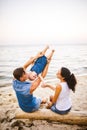 Theme family weekend, beach summer vacation with child. Young stylish family of three dad mom and daughter sit one year with their Royalty Free Stock Photo