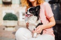 The theme is the friendship of man and animal. Beautiful young red hair Caucasian woman holding a pet dog Chihuahua breed near a Royalty Free Stock Photo