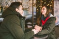 Theme love holiday Valentines Day. pair college students, Caucasian heterosexual lovers in winter, sit table of street cafe Royalty Free Stock Photo