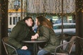 Theme love holiday Valentines Day. pair college students, Caucasian heterosexual lovers in winter, sit table of street Royalty Free Stock Photo