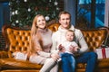 Theme new year and Christmas holidays in family atmosphere. Mood celebrate Caucasian young mom dad and son 1 year old sit on a Royalty Free Stock Photo