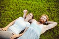 Theme is sport and a healthy lifestyle. A young man and woman couple are resting lying on their backs on the green grass, a lawn i Royalty Free Stock Photo