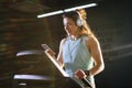 Theme sport and music. A beautiful Caucasian woman running in gym on treadmill. On head big white headphones, the girl listens to Royalty Free Stock Photo