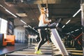 Theme is sport and music. A beautiful inflated woman runs in the gym on a treadmill. On her head are big white headphones, the gir Royalty Free Stock Photo