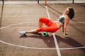 Theme sport and rehabilitation sports medicine. Beautiful strong slender Caucasian woman athlete uses foam roller green field stre Royalty Free Stock Photo