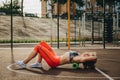 Theme sport and rehabilitation sports medicine. Beautiful strong slender Caucasian woman athlete uses foam roller green field stre Royalty Free Stock Photo