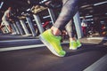 Theme of sport and weight loss. Close-up of the foot of a young strong woman in a light green sneakers on a simulator, running in Royalty Free Stock Photo