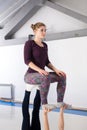 Theme sports health acrobatic yoga. A pair of two young Caucasian girls in the gym doing a base posture chair. Physical and Royalty Free Stock Photo