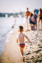 Theme summer outdoor activities near the river on the city beach in Kiev Ukraine. Little funny baby boy running along the river Royalty Free Stock Photo