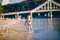 Theme summer outdoor activities near the river on the city beach in Kiev Ukraine. Little funny baby boy running along the river Royalty Free Stock Photo