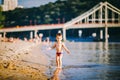 Theme summer outdoor activities near the river on the city beach in Kiev Ukraine. Little funny baby boy running along the river Royalty Free Stock Photo