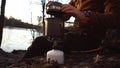 Theme tourism hiking and traveling in nature. Hands Caucasian man uses equipping to cook food outside. tourist places pot of water