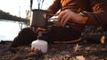 Theme tourism hiking and traveling in nature. Hands Caucasian man uses equipping to cook food outside. tourist places pot of water