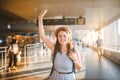 Theme tourism and travel. Young beautiful Caucasian woman in a dress and a hat with a backpack. Tourist mat in the terminal