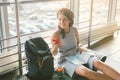 Theme of tourism and travel of young student. Beautiful young caucasian girl in dress and hat sits on floor tourist rug inside Royalty Free Stock Photo