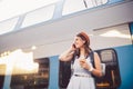 Theme tourism and travel young student. beautiful young Caucasian girl in dress and hat standing at train station near train with