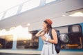 Theme tourism and travel young student. beautiful young Caucasian girl in dress and hat standing at train station near train with