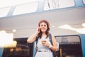 Theme tourism and travel young student. beautiful young Caucasian girl in dress and hat standing at train station near train with