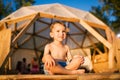 Theme is yoga and children. Caucasian Boy child sitting barefoot cross-legged in lotus position on wooden floor the Royalty Free Stock Photo