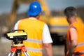 Theodolite and workers at construction site