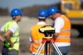 Theodolite and workers at construction site