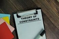 Theory Of Constraints write on a paperwork isolated on Wooden Table