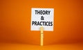 Theory and practice symbol. White paper with words `Theory and practice`, clip on wooden clothespin. Beautiful orange background