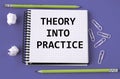 THEORY INTO PRACTICE - words in a white notebook on a blue background with pencils, paper clips Royalty Free Stock Photo