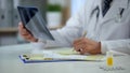 Therapist analyzing patient lungs x-ray to write down diagnosis, treatment