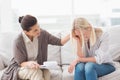 Therapist comforting upset woman on sofa Royalty Free Stock Photo