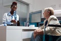 Therapist doctor showing lungs radiography to sick senior woman in wheelchair