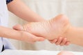 Therapist doing reflexology massage on woman foot