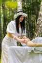 Therapist female doctor making woman relaxing spa face massage with hands outdoors in the forest Royalty Free Stock Photo