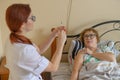 Therapist gives an intramuscular injection to an elderly woman. A nurse holds a syringe with medicine for a senior Royalty Free Stock Photo