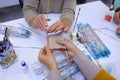 Therapist hands helping disabled person make handmade souvenir using glue and paper