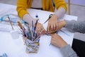 Therapist hands helping disabled person make handmade souvenir using glue and paper