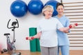 Therapist helping senior woman fit dumbbells Royalty Free Stock Photo