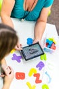 Therapist helping teenage girl with learning difficulties during child therapy. Top view hand detail of a therapist with patient.