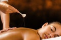 Therapist pouring Ayurvedic oil on female back. Royalty Free Stock Photo