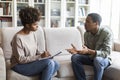 Therapist taking notes on her upset patient at therapy session Royalty Free Stock Photo