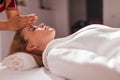 Therapist touching his client`s head with palms