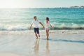 Is there any season more fun than summer. Full length shot of a happy young couple running along the beach. Royalty Free Stock Photo