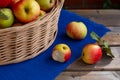 There are 3 apples on the blue tablecloth, one has already been bitten