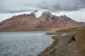 There is a beautiful and spectacular snow mountain under the dark clouds, and there is a light blue lake under the mountain Royalty Free Stock Photo