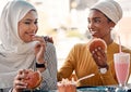 Is there better combination than friendship and food. two affectionate young girlfriends eating burgers at a cafe while Royalty Free Stock Photo