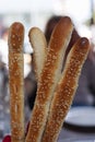 There are bread sticks on the table in the cafe. Local focus